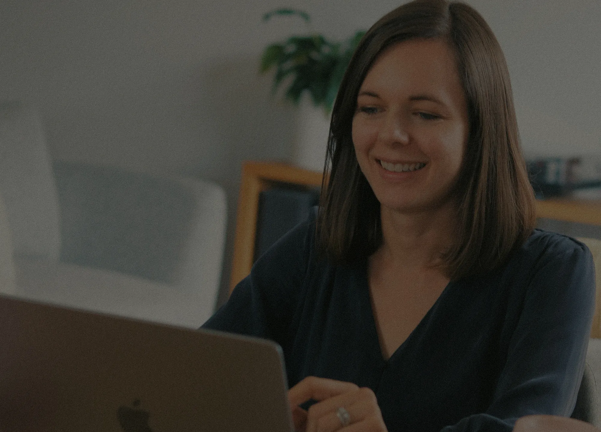 Charlotte Ellis smiling while working on a laptop